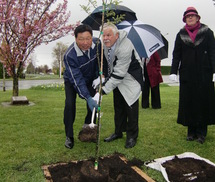 植樹をする梅本委員長とホストの写真