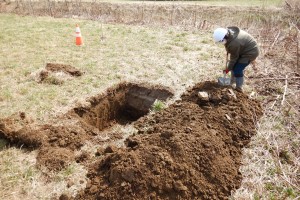 重機が掘り上げた土の中に土器片や石器など遺物がないか確認しています